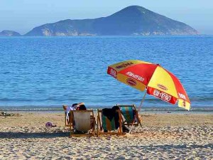 石澳海滩，两个人坐在沙滩椅上撑伞