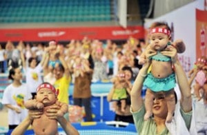 中国婴儿在活动中被父母抱着