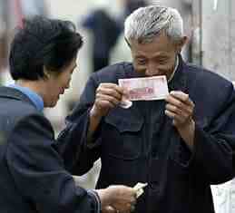 一名中国男子正在检查一张中国纸币，看它是否是假的