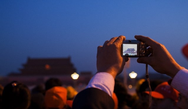 一名游客拿着相机在故宫拍照
