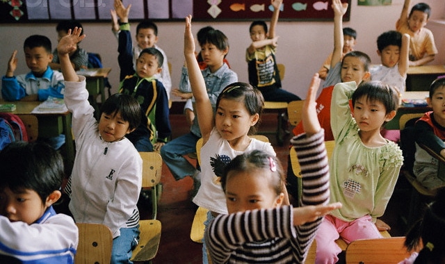 中国的年轻学生在教室里举手。188金宝搏网服务网址